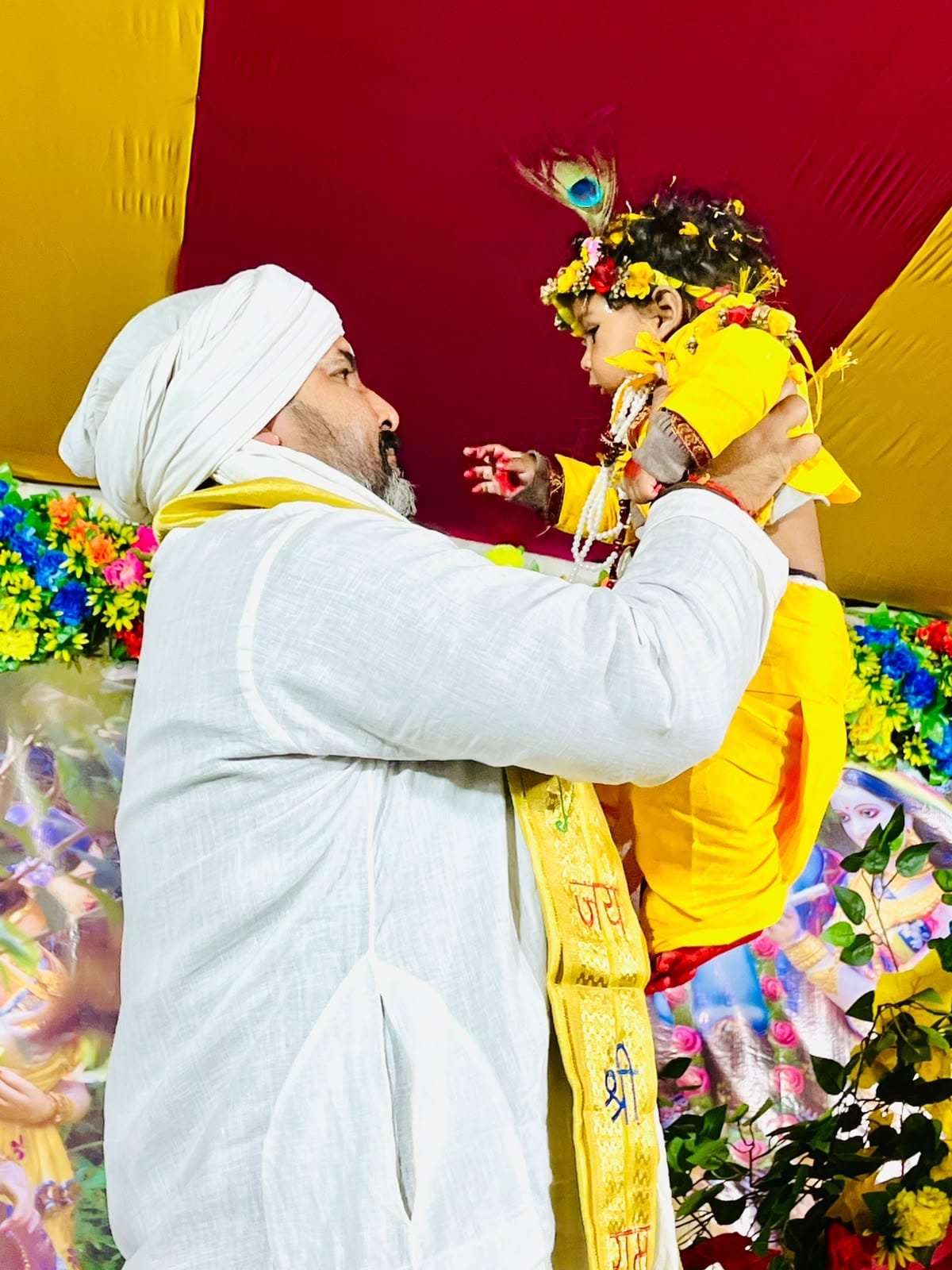 Maharaj Ji blessing a young devotee dressed as Bal Krishna